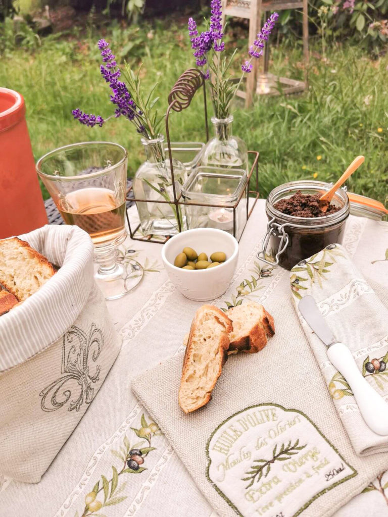 Französisches Ambiente gedeckter Tisch mit Wein Oliven und Brot