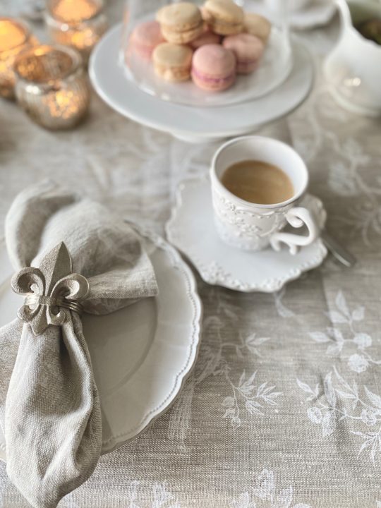 französisches Ambiente auf dem Tisch Macarons und Kaffeetasse mit fleur de lys